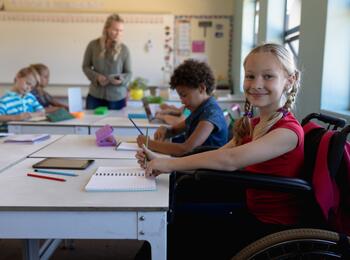 Mädchen im Rollstuhl sitzt in Klassenraum