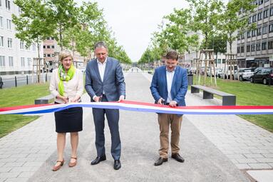 Vergrößerte Ansicht von Oberbürgermeister Dr. Peter Kurz, Bürgermeisterin Felicitas Kubala und Bürgermeister Lothar Quast stehen vor der erneuerten Augusta-Anlage und schneiden ein blau-weiß-rotes Band durch. Im Hintergrund die neu gepflanzten Platanen. 