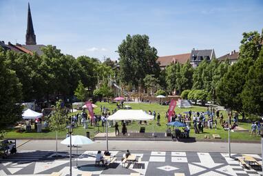 Vergrößerte Ansicht von 2022 wurde der umgestaltete Neumarkt seinen Nutzer*innen übergeben. Durch die Umgestaltung des Neumarktes kann der zentrale Platz in der Neckarstadt-West wieder seinen Anforderungen an Zusammenleben, Erholung, Spielen und Kommunikation gerecht werden. Die Umgestaltung ist ein gelungenes Beispiel für Maßnahmen der Initiative der Lokalen Stadterneuerung (LOS), die alle das Ziel haben, Stabilität und Verbesserungen im Quartier zu bewirken.