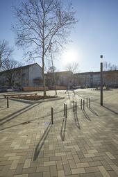 Vergrößerte Ansicht von Der neu gestaltete Marktplatz in Rheinau wurde 2022 mit einem Stadtteilfest wiedereröffnet. Durch die Einrichtung einer Fußgängerzone, das Verlegen eines hellen Pflasters, neue Bäume und Stauden sowie die Aufstellung von mehreren Sitzmöglichkeiten wurde die Aufenthaltsqualität des Platzes gesteigert und er bietet so die Chance, auch im Alltag zum belebten Herzen der Rheinau zu werden. Deshalb wurden Rheinauerinnen und Rheinauer von Anfang an in die Planung eingebunden.