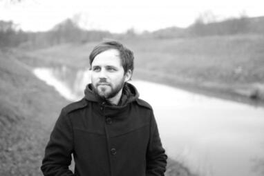 Vergrößerte Ansicht von Florian Wacker auf einem schwarz-weiß-Foto, wie er auf einer Wiese läuft.