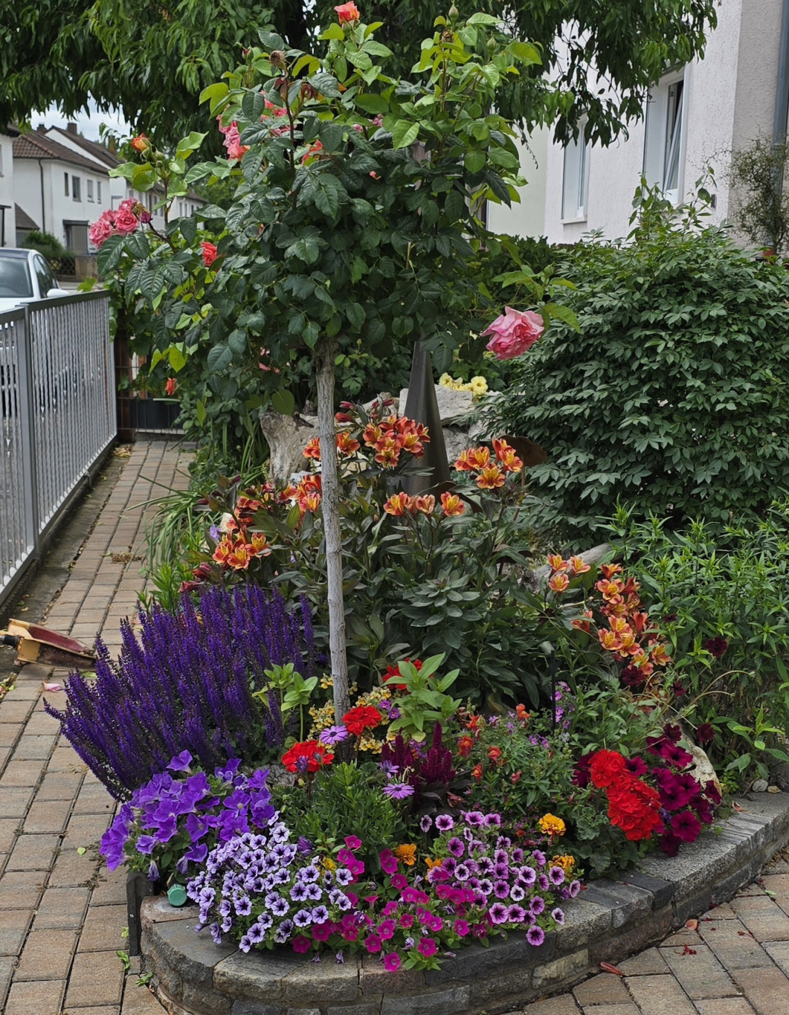 Üppig blühendes Beet in einer Hauseinfahrt