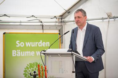 Vergrößerte Ansicht von Oberbürgermeister Dr. Peter Kurz an einem Rednerpult in einem weißen Zelt. Hinter ihm ein Banner mit dem Logo der Spenden-Aktion für die Augusta-Anlage. 