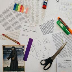 Vergrößerte Ansicht von Foto von Arbeitsmaterialien wie ausgedruckten Texten sowie Zeichnungen eines Pre-Texts-Workshops