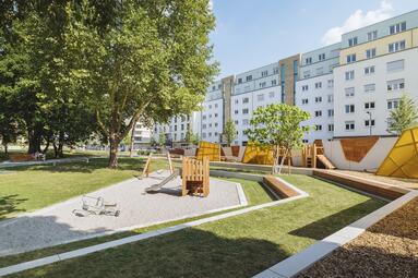 Vergrößerte Ansicht von Besonderheit und Alleinstellungsmerkmal des Glückstein-Parks ist ein hochwertiger, barrierefrei zugänglicher Spielplatz, der über ein Karussell verfügt, das auch von Kindern im Rollstuhl genutzt werden kann.