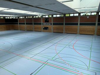 Vergrößerte Ansicht von Die 1986 von der Daimler-Benz AG als großzügige Spende erbaute Herbert-Lucy-Halle wird von Schulen und Vereinen auf dem Waldhof seit Jahrzenten lebhaft genutzt. 2022 wurde der Hallenboden inklusive seiner Unterkonstruktion erneuert. Im Rahmen des Bodenaustausches wurde auch eine Optimierung der Energieversorgung vorgenommen. Die Herbert-Lucy-Halle ist als Austragungsort für wichtige Wettkämpfe in die Sportanlage Alsenweg integriert.