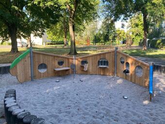 Vergrößerte Ansicht von Der Spielplatz am Saßnitzer Weg wurde 2022 umfänglich saniert und deutlich aufgewertet, unter anderem mit neuen Spielgeräten für Kleinkinder und ältere Kinder. Für Kleinkinder gibt es jetzt eine Schaukel und einen Sandbereich mit einem großen neuen Spielgerät in Form einer Raupe. Für jüngere Kinder ist ein Balancier-Motorik-Pfad entstanden und für ältere Kinder gibt es jetzt einen anspruchsvolleren Kletterpark mit vielen Seil-Elementen und einer Vogelnest-Schaukel.