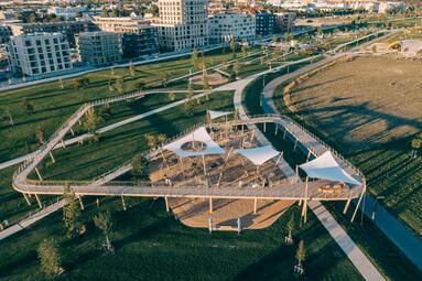 Vergrößerte Ansicht von Die Spielstation "Vernetzung" in der Parkschale Käfertal von oben fotografiert. Man erkennt den Steg, der sich um den Spielplatz windet.