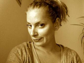 Vergrößerte Ansicht von Das Bild hat einen gewollten Gelbstich. Tamara Bach schaut seitlich in die Kamera.