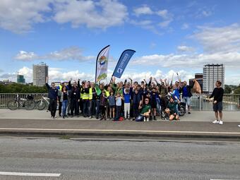 Vergrößerte Ansicht von Das Foto zeigt jubelnde Teilnehmende, die sich nach der Reinigungsaktion auf der Konrad-Adenauer-Brücke getroffen haben.