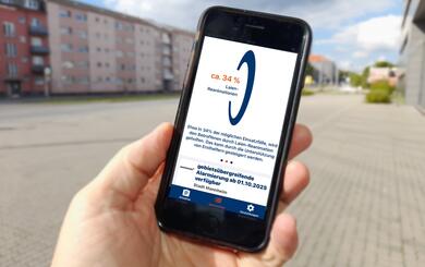 Eine Hand hält ein Handy. Der Bildschirm zeigt die App Katretter mit einem Hinweis zur Laien-Reanimation