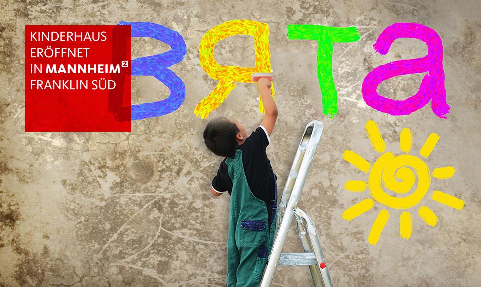 Kind schreibt mit Malerpinsel Buchstaben an eine Wand