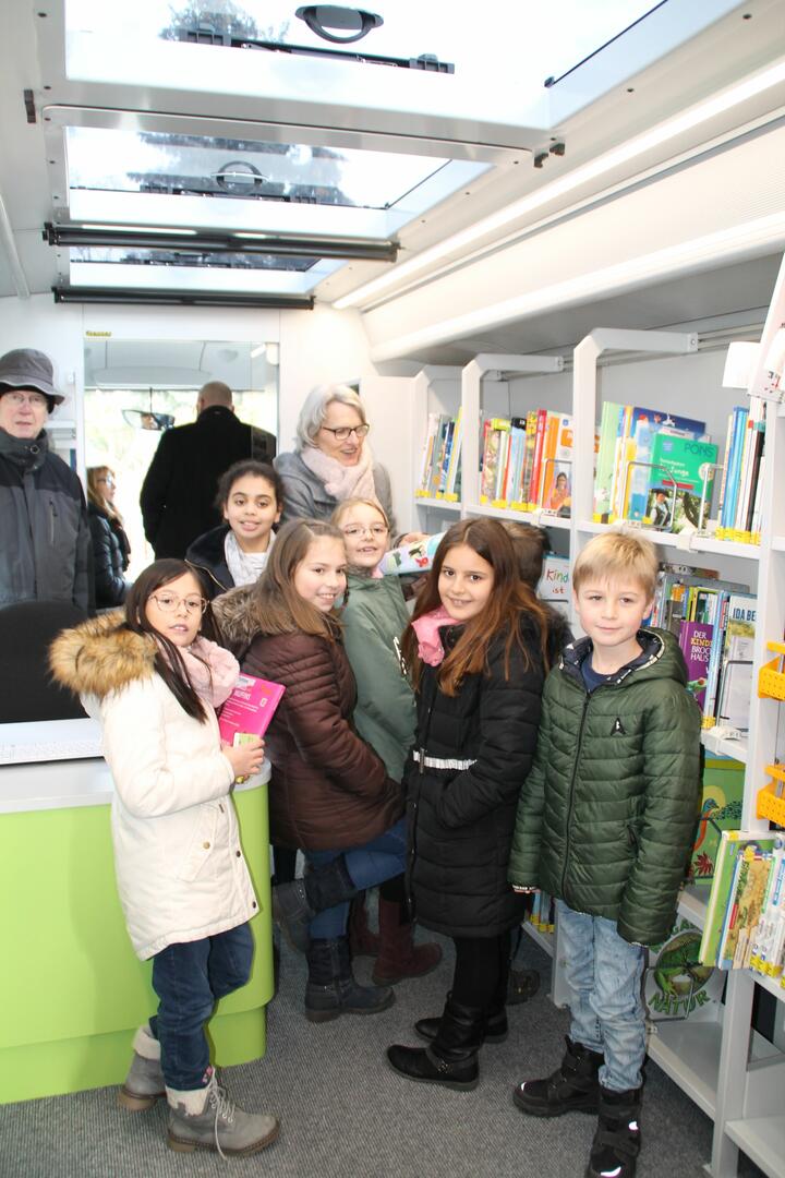 Die Mobile Bibliothek unterstützt mit ihren über 3000 mitgeführten Medien vor allem die Leseförderung. Bildungsbürgermeisterin Dr. Ulrike Freundlieb zeigt den Kindern die Bücher.
