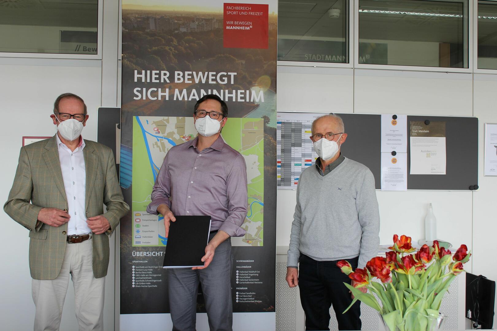 Bürgermeister Eisenhauer mit zwei Vertretern des SV Seckenheim. BM Eisenhauer hält den unterzeichneten Vertrag in den Händen.