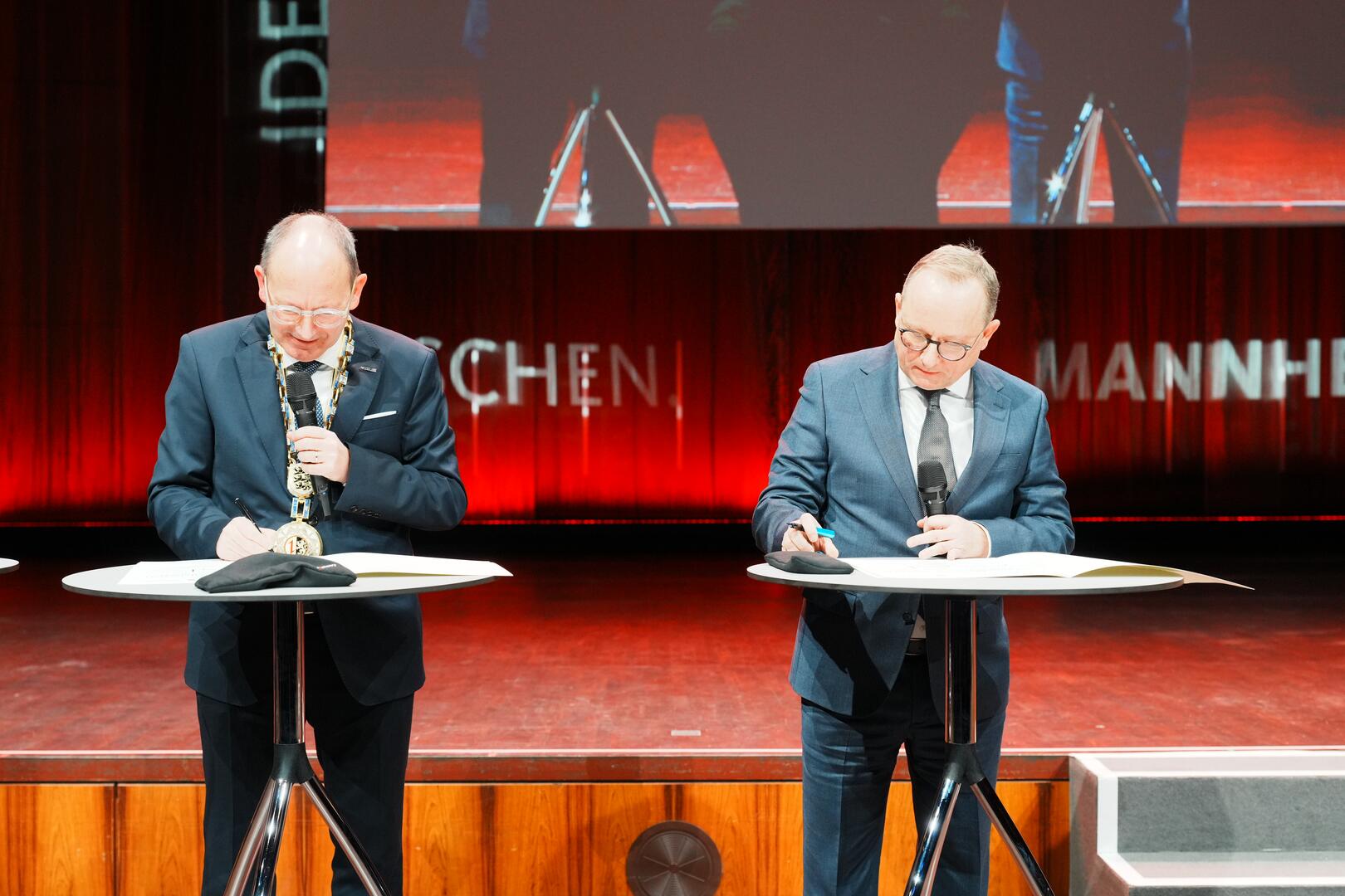 Prof. Dr. Klaus Blettner, Oberbürgermeister der Stadt Ludwigshafen, und Oberbürgermeister Christian Specht unterzeichnen die Verträge zur Gründung der „Brückenbaugesellschaft Ludwigshafen-Mannheim“