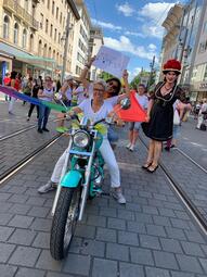 Vergrößerte Ansicht von Dieses Bild zeigt zwei Frauen auf einem Hellblauen Motorrad