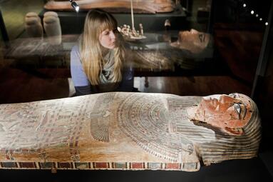 Vergrößerte Ansicht von Frau betrachtet ägyptischen Sarkophag