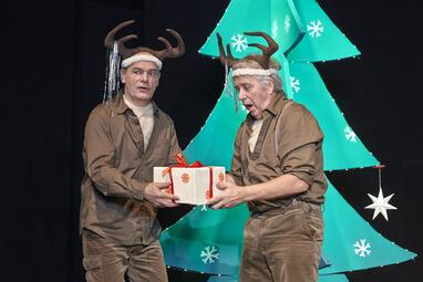 Vergrößerte Ansicht von Zwei Männer, verkleidet als Rentiere, vor weihnachtlicher Kulisse