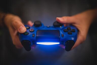 Vergrößerte Ansicht von Zwei Hände, die einen blauen Spiele- Controller halten
