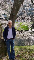 Vergrößerte Ansicht von Ein Mann (Hasan Dewran) steht vor einem blühenden Baum
