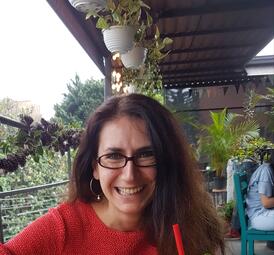 Vergrößerte Ansicht von Foto von Journalistin und Autorin Uta-Caecilia Nabert. Sie sitzt auf einer Terrasse und lächelt in die Kamera.