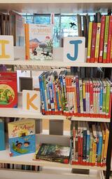 Vergrößerte Ansicht von Bücherregal in der Zweigstelle Herzogenried mit bunten Kinderbüchern