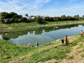 Vergrößerte Ansicht von Das Foto zeigt Teilnehmer*innen des Cleanup im Jungbusch bei der Reinigung des Verbindungskanals..