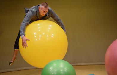 Vergrößerte Ansicht von Uwe Topmann liegt mit dem Bauch auf einem Gymnastikball