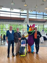 Vergrößerte Ansicht von Dr. Klaus Wolff und Karl-Heinz Schneider vom Badischen Blinden- und Sehbehindertenverein V.m.K. (BBSV), Heinrich Schaudt von der Arbeitsgemeinschaft Barrierefreiheit Rhein-Neckar e.V, das Maskottchen Chämy und Ursula Frenz, Beauftragte für die Belange von Menschen mit Behinderungen bei der Preisverleihung in Ulm