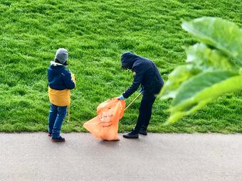 Vergrößerte Ansicht von Das Foto zeigt zwei Personen beim Aufräumen am Neckarufer.