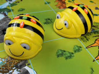 Vergrößerte Ansicht von Zwei kleine gelbe Roboter mit schwarzen Querstreifen, Leuchtdioden und einem freundlichen Gesicht.