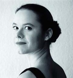 Vergrößerte Ansicht von Ein schwarz-weisses Bild von Antje Wagner. Sie schaut über ihre linke Schulter in die Kamera.