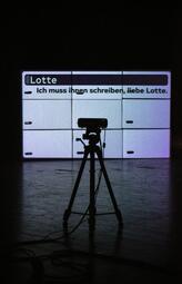 Vergrößerte Ansicht von Projektion einer Notiz auf Kartons: Ich muss ihnen schreiben, liebe Lotte.