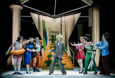 Vergrößerte Ansicht von Sechs Frauen in unterschiedlichster Kleidung, die alle panisch zu einer zerzausten, weinenden Frau in einem grauen Anzug gestikulieren.