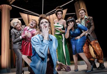 Vergrößerte Ansicht von Sechs Frauen in unterschiedlichsten Kleidungsstilen schreien, weinen und starren in Schock auf etwas unter ihnen.