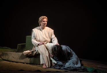 Vergrößerte Ansicht von Julia Faylenbogen (Kundry) liegt zusammengekauert zu Jonathan Stoughtons (Parsifal) Füßen