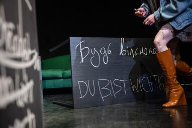 Vergrößerte Ansicht von Sari Dorian tritt aus dem Bild und hält ein Stück Kreide. Auf der Tafel neben ihr steht "Du bist wichtig" auf Ukrainisch und auf Deutsch