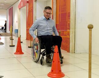 Vergrößerte Ansicht von Bürgermeister Ralf Eisenhauer beim Selbsterfahrungsparcours mit Rollstuhl