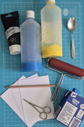 Vergrößerte Ansicht von Verschiedene Bastel-Utensilien liegen auf einer blauen Matte.
