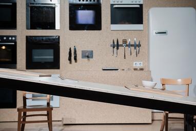 Vergrößerte Ansicht von Die Tischplatte in Schieflage. Holzbrett, Schüssel und Besteck bleiben an ihrer Stelle.