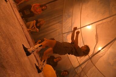 Vergrößerte Ansicht von Ausschnitt eines Sitzkreises, im Vordergrund steht eine Person, von welcher nur die Cowboystiefeln zu erkennen sind.