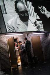 Vergrößerte Ansicht von Zwei Männer wollen durch eine Tür. Ein Mann lässt sie nicht rein.