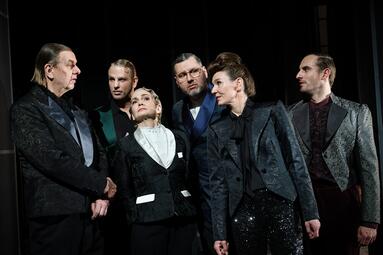 Vergrößerte Ansicht von Sechs Menschen in dunklen, edlen Anzügen aus Samt.