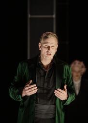 Vergrößerte Ansicht von Ein blonder Mann in einem dunkelgrünen Samtanzug.