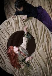 Vergrößerte Ansicht von Zwei Personen interagieren an der Armlehne des großen, beigen Sofa, eine Person mit roten Haaren greift nach oben, die andere lehnt sich von oben hinein