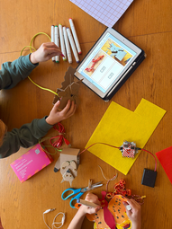 Vergrößerte Ansicht von Auf einem Tisch liegen Bastelmaterialien und digitale Tools.