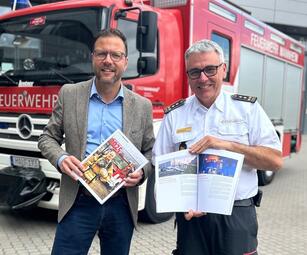 Vergrößerte Ansicht von Bürgermeister und Sicherheitsdezernent Dr. Volker Proffen und stv. Feuerwehr-Kommandant Jens Stiegel mit dem Jahresbericht 2025 der Feuerwehr Mannheim.
