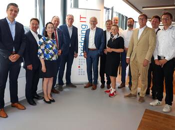 Oberbürgermeister Dr. Peter Kurz (5. v. l.) und Klaus Baumgärtner, Geschäftsführer der bridgingIT (6. v. l.) gemeinsam mit Vertretern der Stadtspitze und Wirtschaftsförderung sowie Mitarbeiterinnen und Mitarbeitern von bridgingIT
