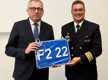 OB Dr. Peter Kurz übergibt das Straßenschild F2, 22 an Markus Venker, Kommandant der Fregatte Baden-Württemberg