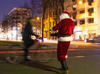 Nikolaus übergibt radelnden Passanten Geschenke